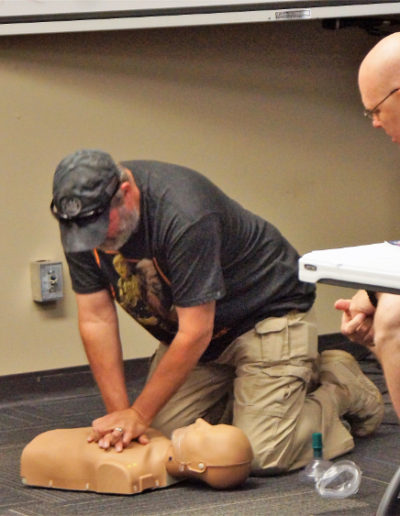 Picture of a student practicing chest compressions on an adult manikin