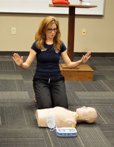 Photo of instructor demonstrating AED training - how to get into the "all clear" poise.