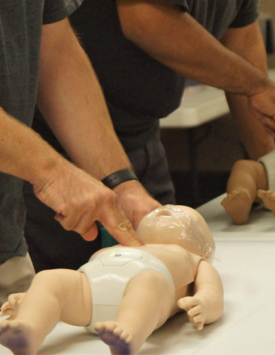 Picture of students administering CPR compressions to infant manikins